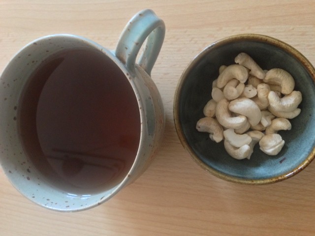 Cup of yogi tea and cashew nuts  